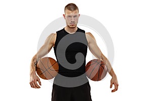 Handsome muscled man, basketball player posing with two balls isolated on white studio background. Sport, motion