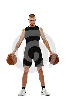 Handsome muscled man, basketball player posing with two balls isolated on white studio background. Sport, motion
