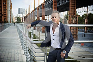 Handsome muscular blond man standing in city environment