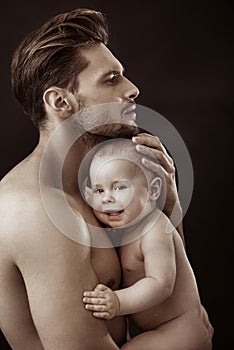 Handsome, muscular father carrying gis cute son photo