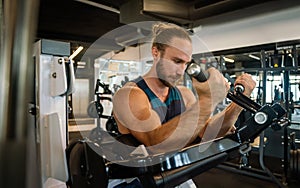 Handsome muscular man working out hard at gym