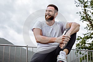 Handsome muscular hunk man looking at mountains from the peak.