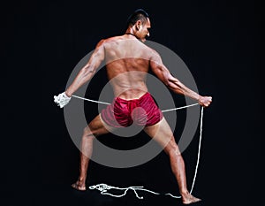 Handsome Muscular Man displays ancient Asian traditional martial arts, Thai Boxing or Muay Thai