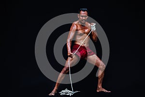 Handsome Muscular Man displays ancient Asian traditional martial arts, Thai Boxing or Muay Thai