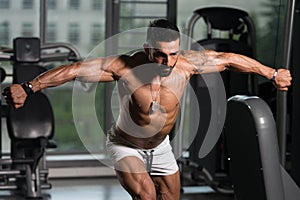 Handsome Muscular Man Flexing Muscles in Gym