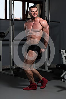 Handsome Muscular Man Flexing Muscles In Gym