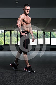 Handsome Muscular Man Flexing Muscles In Gym