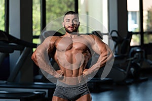 Handsome Muscular Man Flexing Muscles In Gym