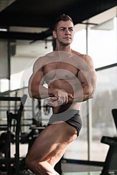 Handsome Muscular Man Flexing Muscles In Gym