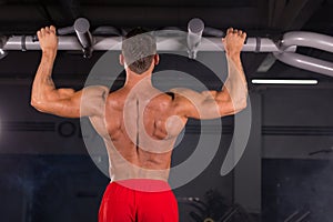 Handsome Muscular Man With Perfect Body Doing Pull Ups in gym