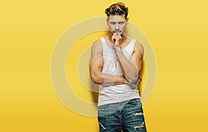 Handsome, muscular man posing on a yellow background photo
