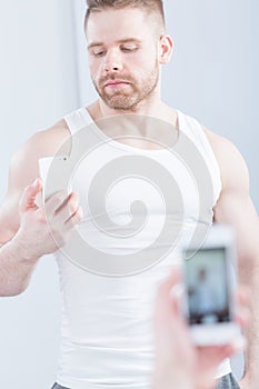 Handsome muscular man taking photo