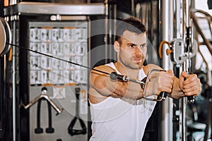 Handsome muscular man working out hard at gym