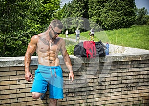 Handsome Muscular Shirtless Hunk Man Outdoor in City Park