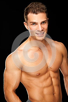 Handsome muscular young man isolated on black