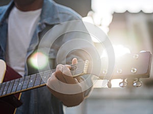 Handsome musician playing acoustic guitar on blur background. mu