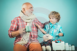 Handsome old man grandfather is having pain and his grandson supports him. Happy child pharmacist showing drug to senior