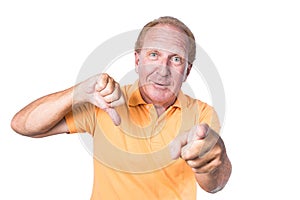 Handsome old man with orange polo-shirt shows thumb up and pointin
