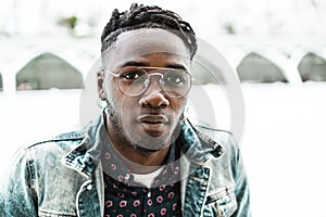 Handsome portrait African American guy walking city street with modern glasses and casual dress