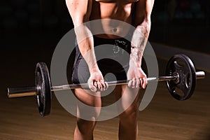 Handsome power athletic man with barbell. Strong bodybuilder with six pack, perfect abs, shoulders, biceps, triceps and