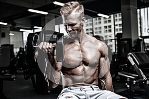 Handsome power athletic man on diet training pumping up muscles