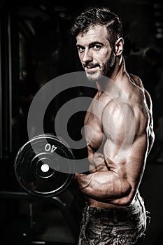 Handsome power athletic man on diet training pumping up muscles