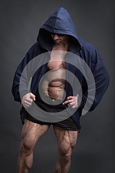 Handsome power athletic man with great physique in a blue hoodie