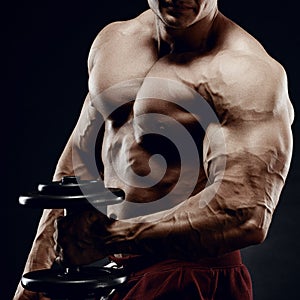 Handsome power athletic man in training pumping up muscles with