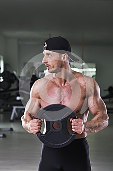 Handsome powerful athletic man performing static exercise with weight