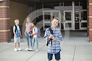 Handsome pre-adolescent teen boy student hanging out with friends after school.