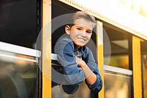 Handsome preteen boy looking out of school bus window