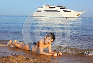 Handsome preteen sun tanned boy swimming on the Res sea beach an