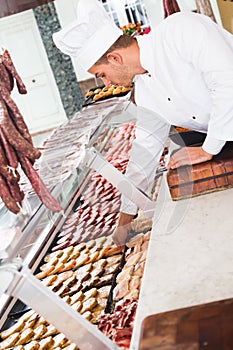 Handsome professional cook laying out food