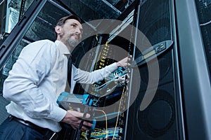 Handsome professional technician repairing the network server