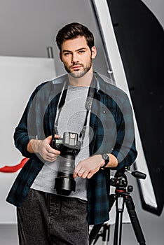 handsome professional young photographer looking at camera