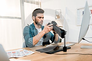 handsome professional young photographer using camera