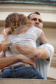 Handsome proud man hugging woman close on balcony