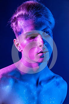 Handsome pumped up guy with naked torsos. Sports guy, attractive male body. Studio shooting with color filters