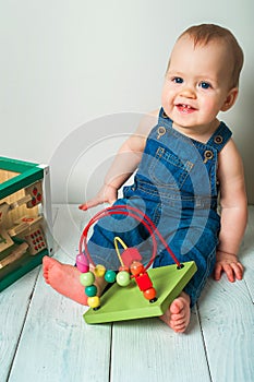 Handsome red-haired baby eating in children`s chair. First feeding children with porridge, vegetables, fruits, meat