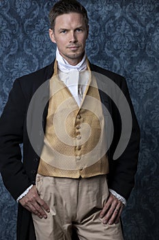 A handsome Regency gentleman wearing a gold waistcoat, breeches, and a black coat