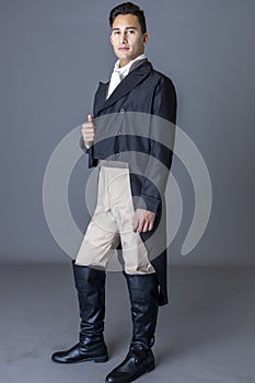 A Regency gentleman wearing a tailed jacket against a grey backdrop photo