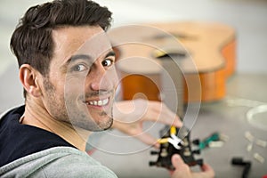 handsome repairman repairing guitar