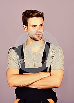 Handsome repairman. Worker violet background. Man repairman builder in work clothes. Troubleshoot and fix faulty