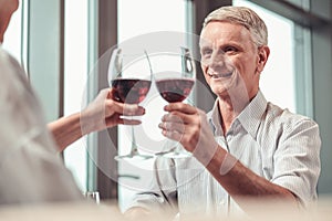 Handsome retired man drinking red wine in a restaurant