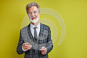 Handsome rich man in suit isolated over green background