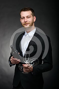 Handsome romantic man holding bottle and glasses of wine