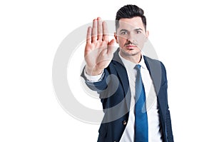 Handsome sales man showing stop or stay gesture