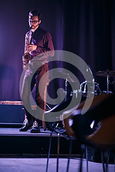 Handsome saxophone player performing on a stage