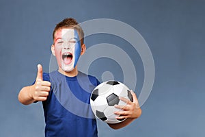 Handsome screaming french fanboy holds soccer ball and gesturing thumbs up