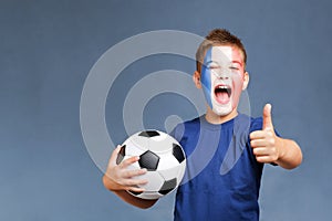 Handsome screaming french fanboy holds soccer ball and gesturing thumbs up